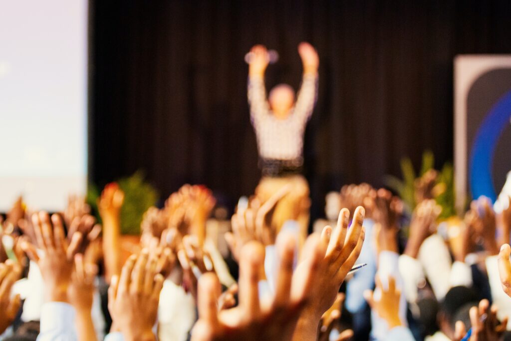 Audience cheering on a speaker on the stage